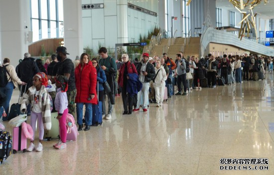 3月27日,乘客在美国纽约拉瓜迪亚机场排队等待安检。新华社记者张凤国摄