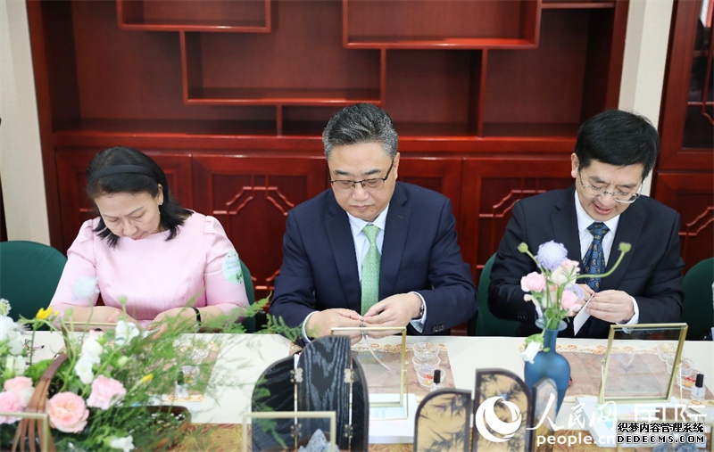 嘉宾参与金丝宝石画宋锦小马，从左至右分别为柬埔寨驻华大使宋嘉薇，中国—东盟中心秘书长史忠俊与北京市对外友协党组书记、常务副会长王禹。人民网 王婧摄